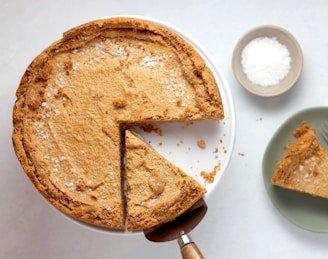 Close-up of a golden British meat pie with flaky crust on a rustic wooden board.