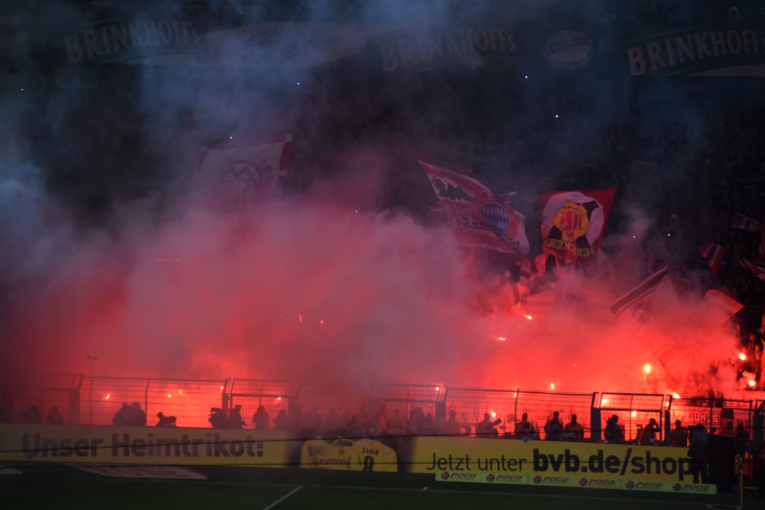 a large crowd of people watching a soccer game, FC Bayern Munich Fans on Fire with Bengalos