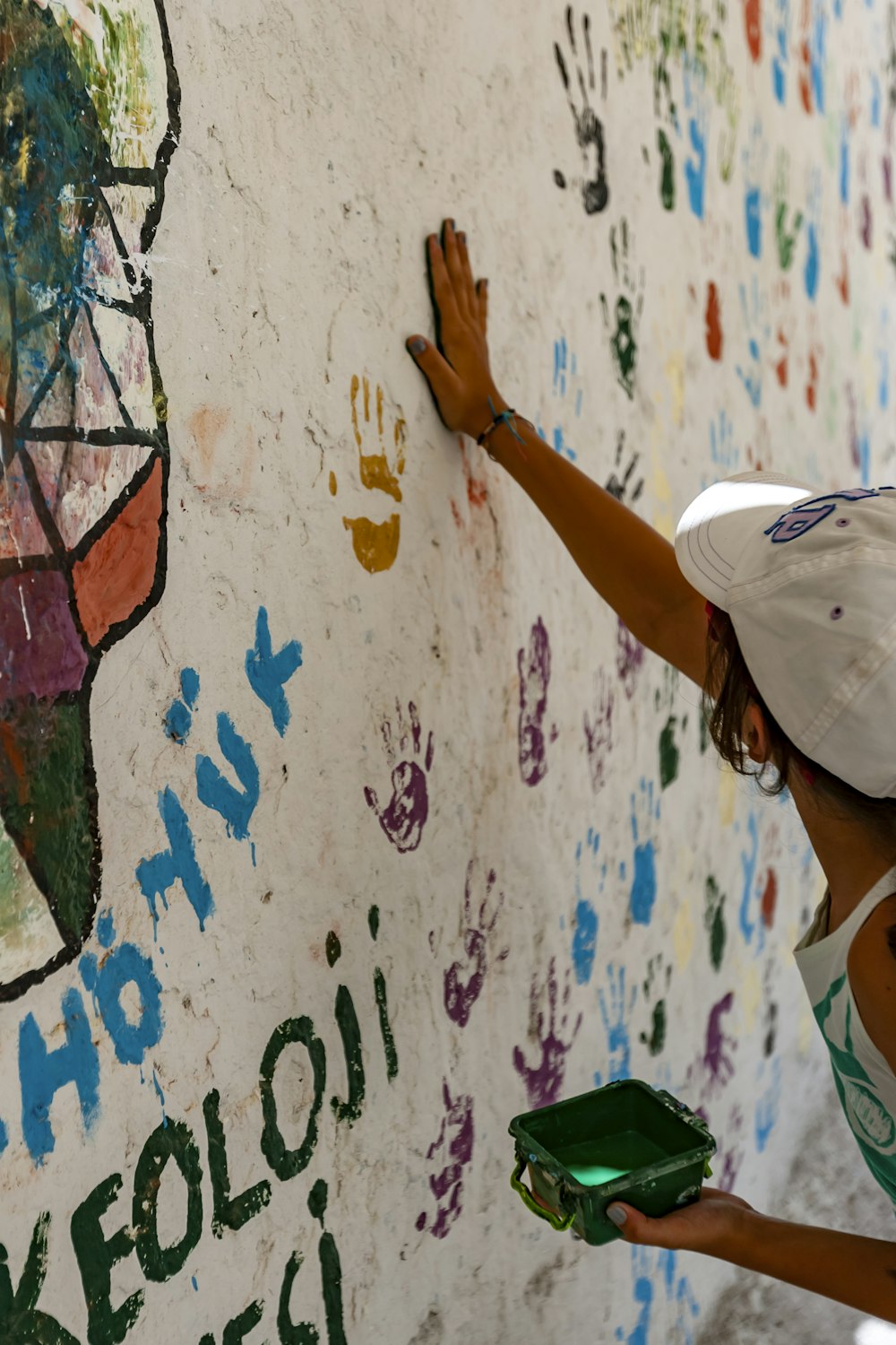 Mujer pintando pared con la palma de su mano derecha