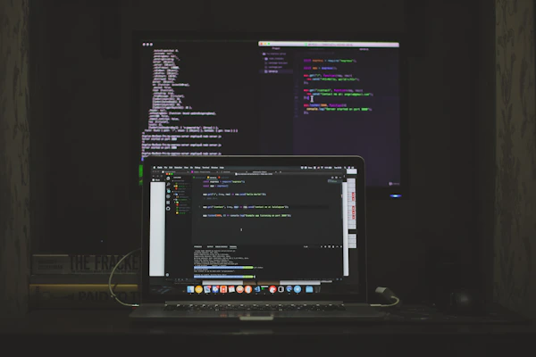 MacBook Pro showing code editor with programming setup