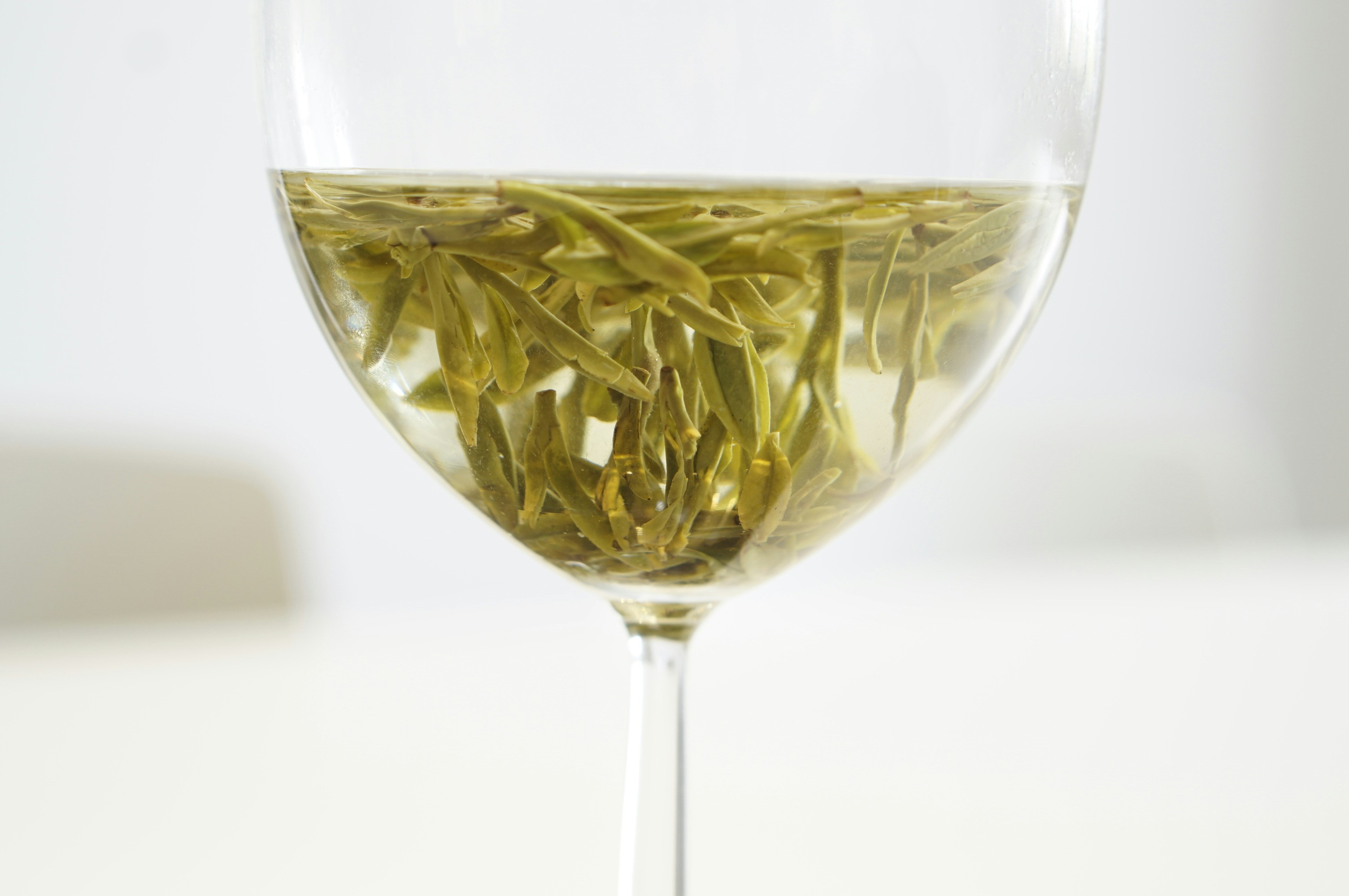 green flower petals in clear glass goblet