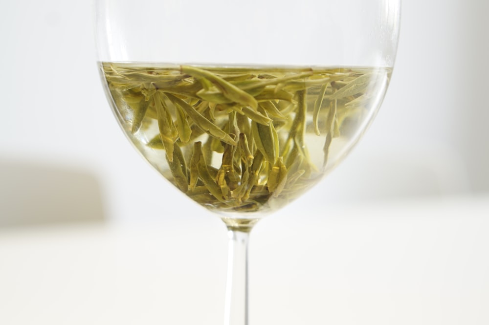green flower petals in clear glass goblet