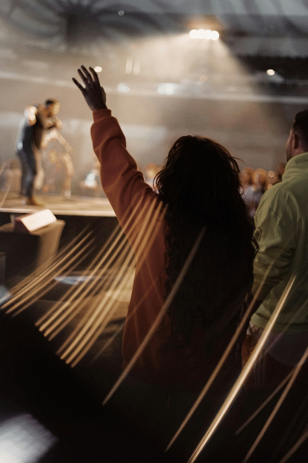 pessoas em pé na frente do palco com o homem se apresentando