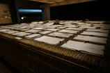 A rustic wooden table displaying several sketchbooks stacked with worn leather covers.
