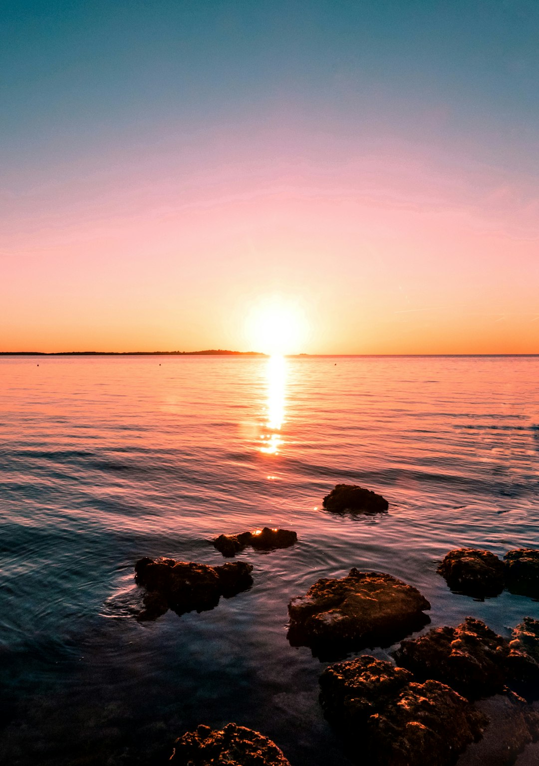 stones on shore during sunrise