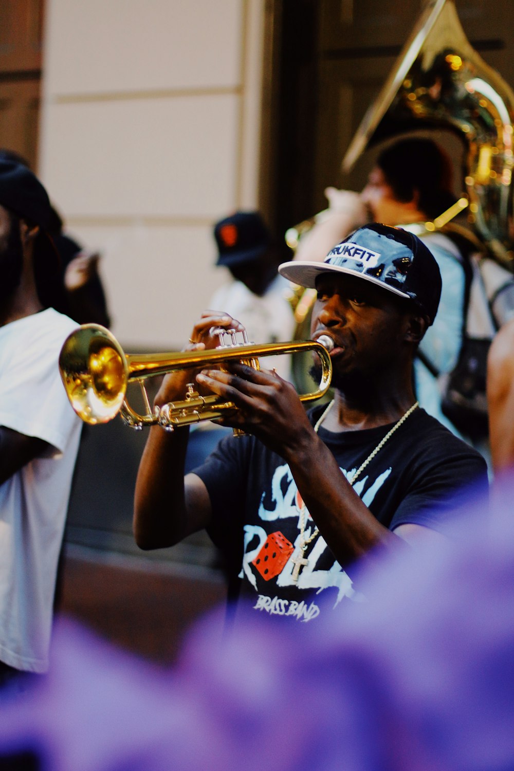 man playing with trumpet surrounded with people