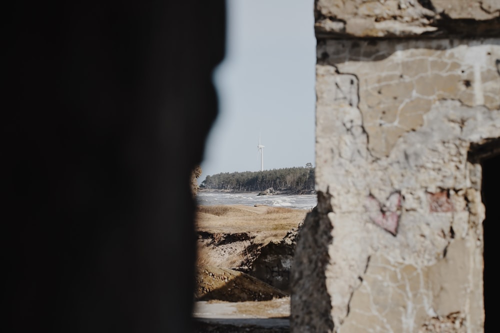 a view of a beach through a hole in a wall