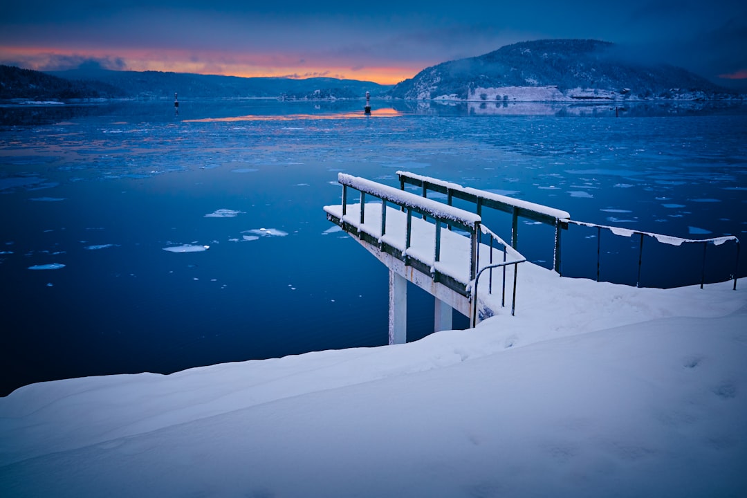 bridge covered by snow near calm water