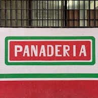A warm, inviting bakery storefront with the panalcuadrado sign visible.