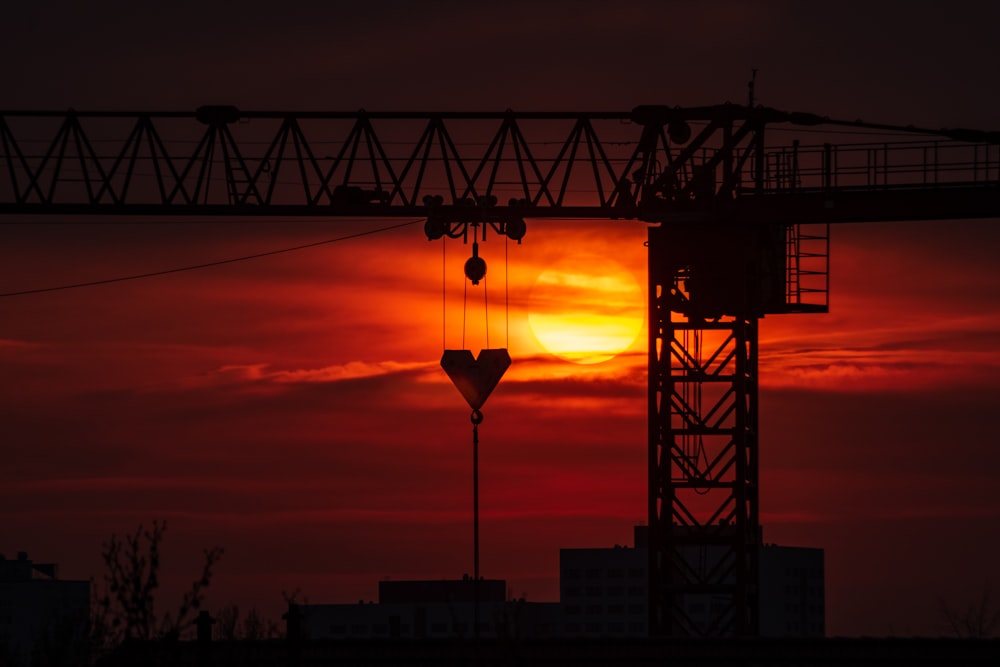 silhouette of tower crane during golden hour