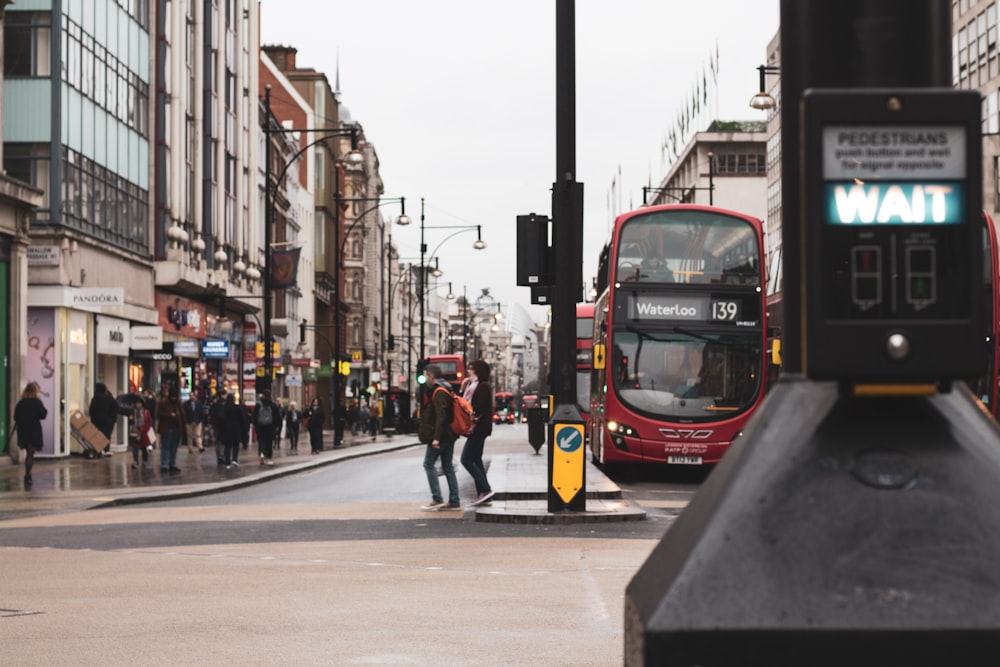 people standing beside red bus