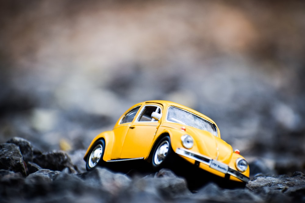yellow Volkswagen Beetle coupe die-cast metal model on rocky terrian