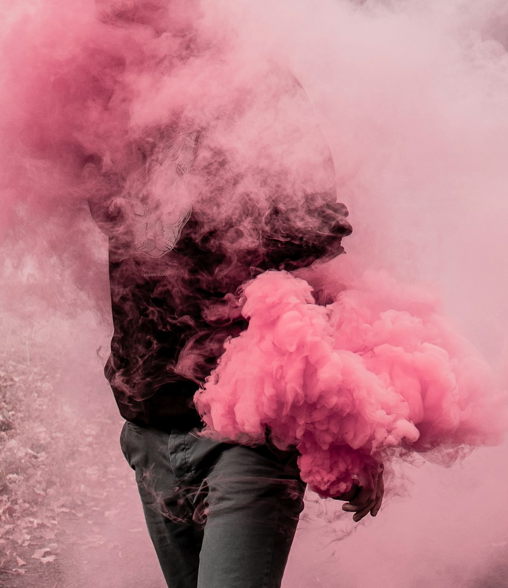 person surrounded by pink smoke
