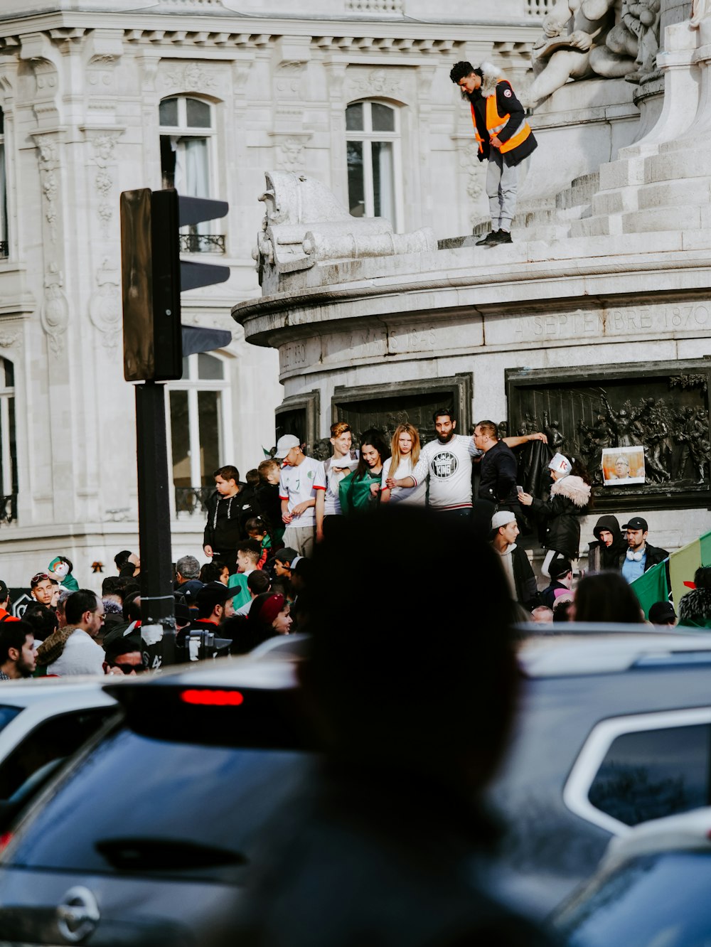 personnes debout et assises à l’extérieur près d’un bâtiment