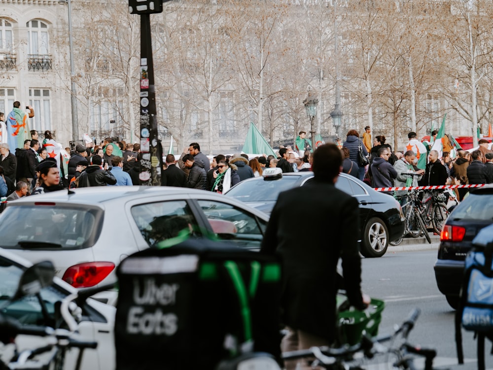 a crowd of people standing around parked cars