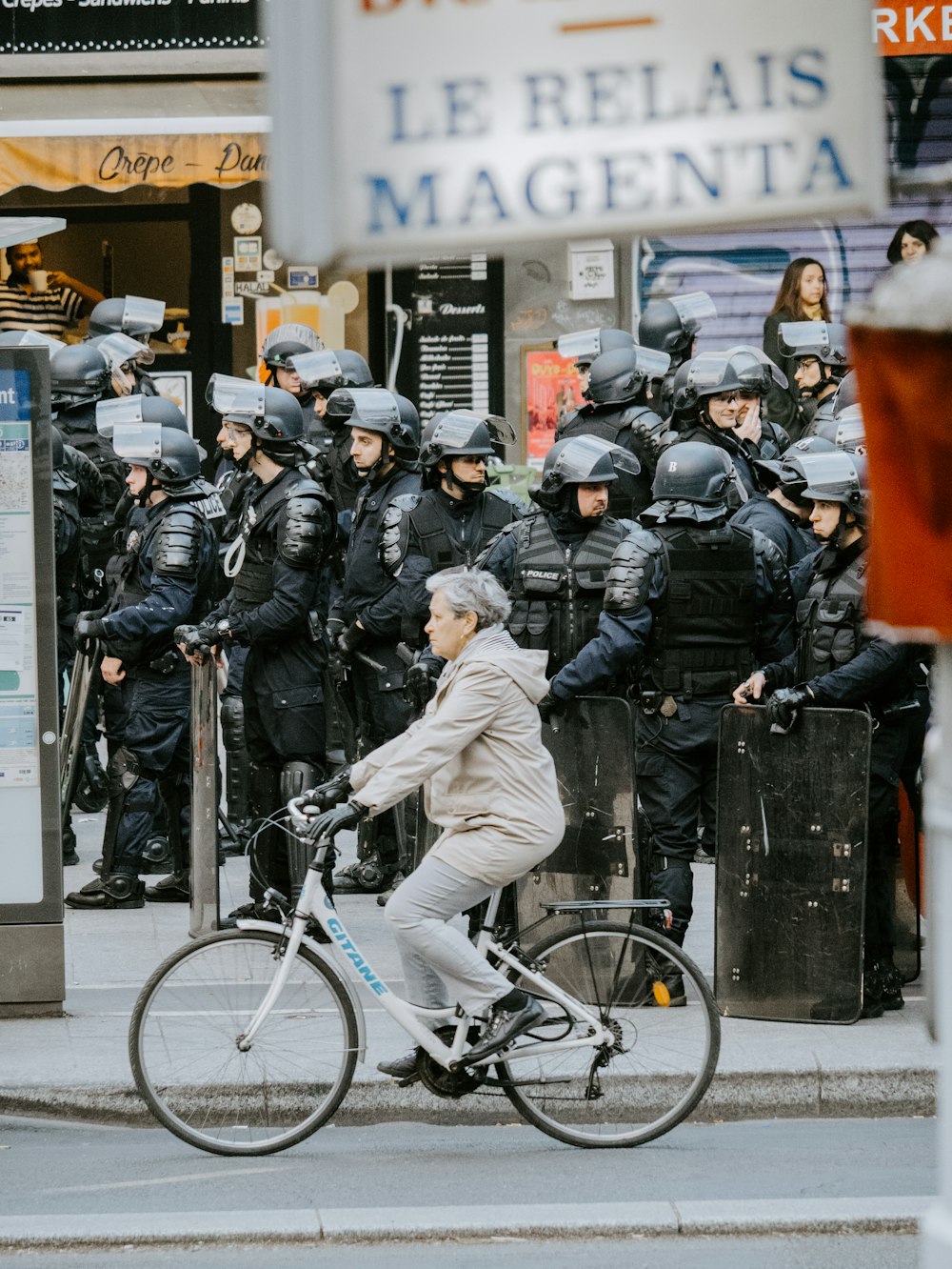 woman biking near people on sidewalk