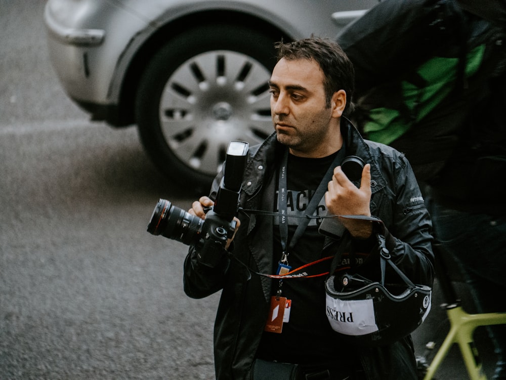 man holding camera standing near SUV