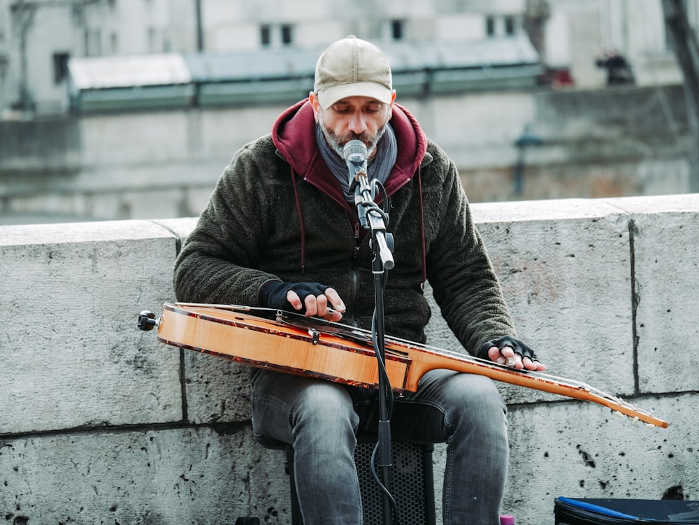 man playing guitar and singing on street during daytime