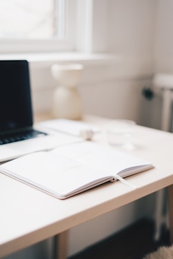 A minimalist desk with an open journal, a fountain pen, and soft natural light highlighting a clean workspace.