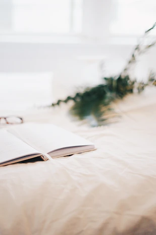 A quiet morning scene with a notebook open next to a window overlooking a garden.