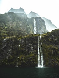 waterfalls under white sky