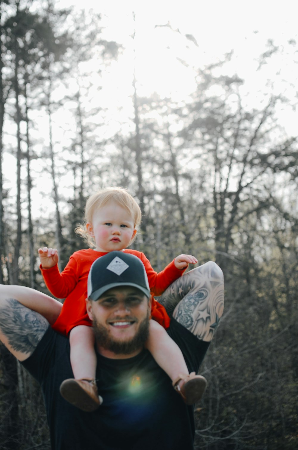 female toddler riding on man's shoulders