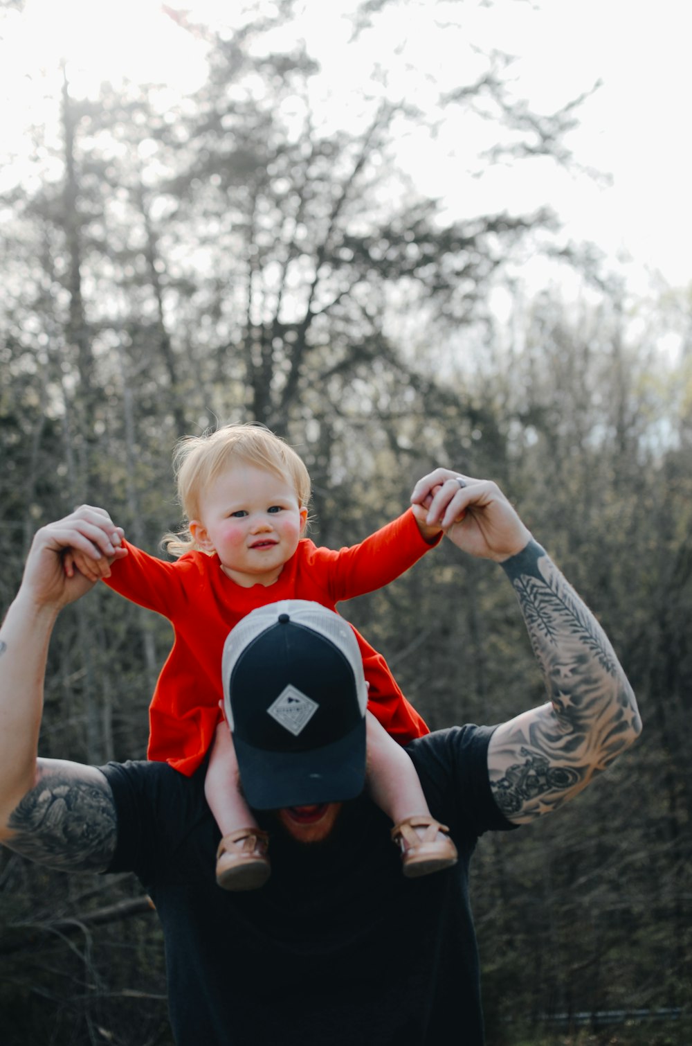 man carrying toddler during daytime