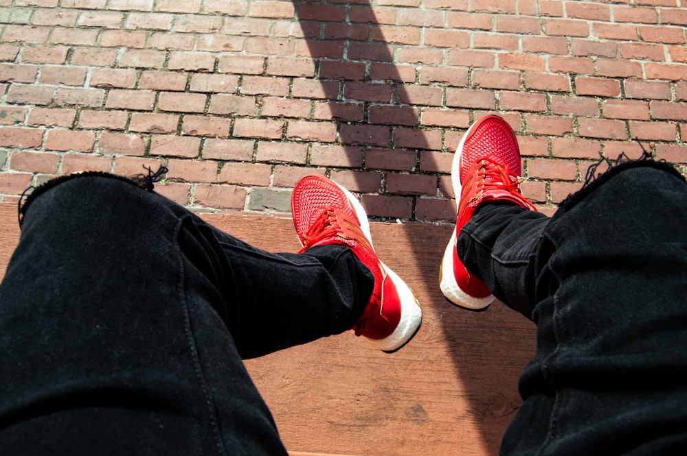 person wearing black denim jeans and red running shoes photo – Free Apparel  Image on Unsplash