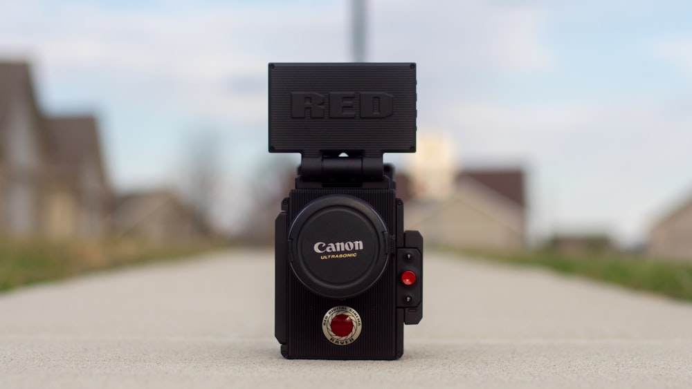 black Canon camera in road during daytime