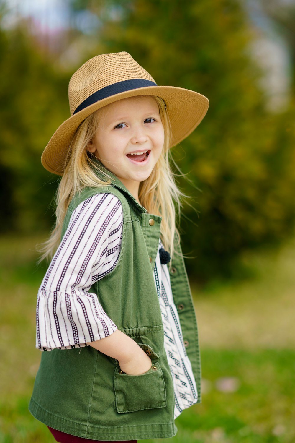 Fotografía de enfoque selectivo de chica sonriendo con sombrero para el sol