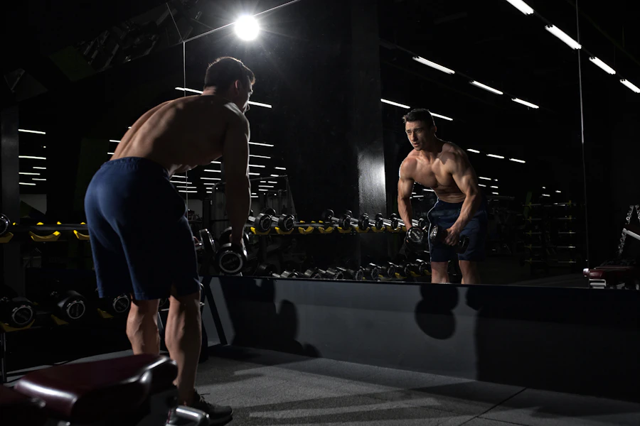 Sporter met een dumbbell voor de spiegel in de sportschool