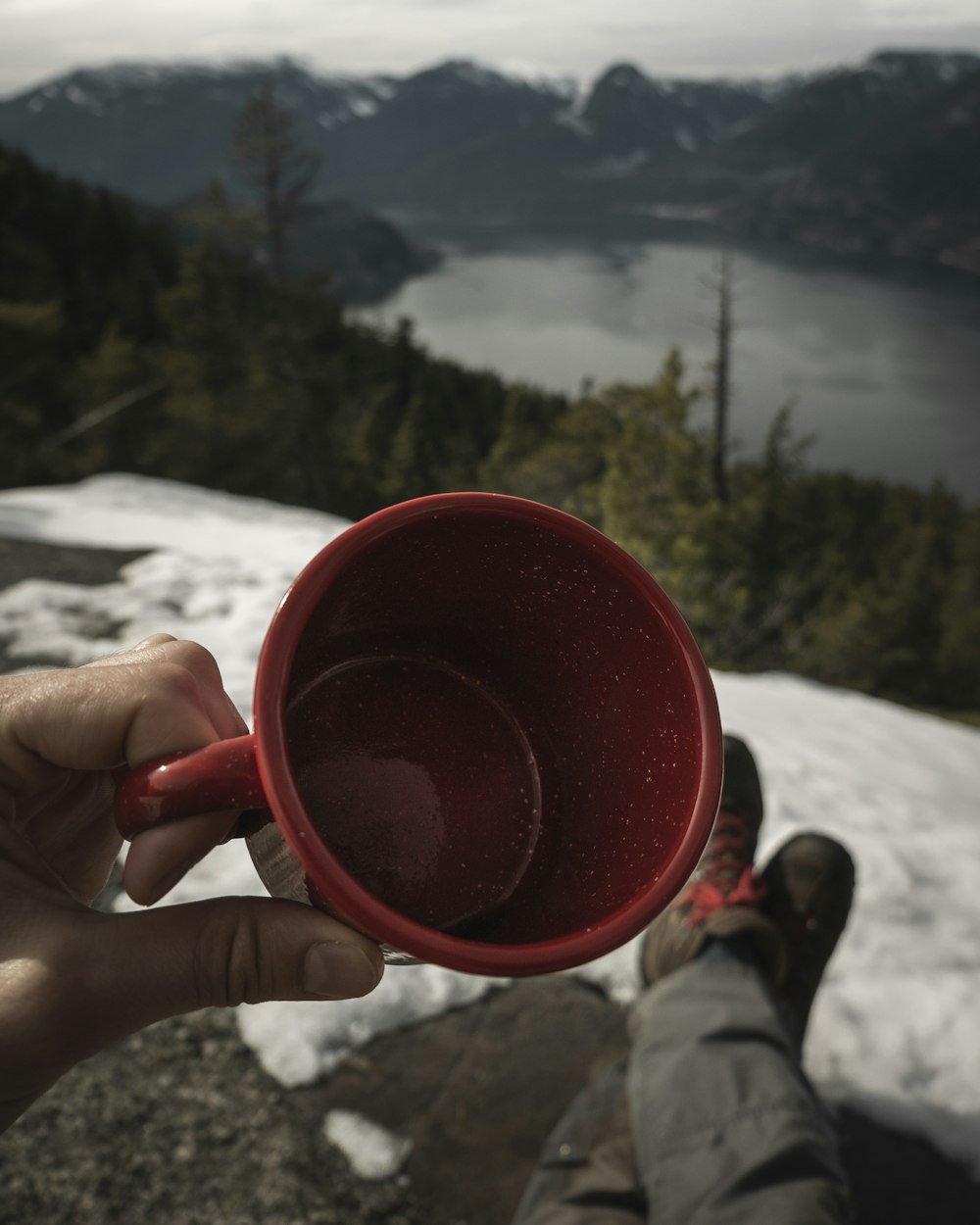 person holding red ceramic mug