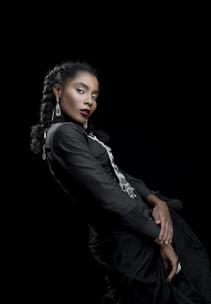 A confident woman dressed in sleek black attire, embodying strength and elegance like a black panther.