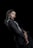 A woman with braided hair dressed in a black outfit with silver accents, posing against a dark background. Her expression is poised and confident, and she is adorned with long dangling earrings. The composition highlights elegance and sophistication.