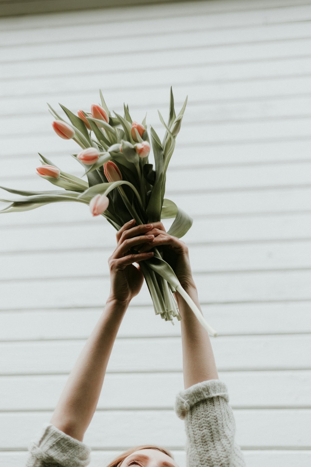 woman raising bouquet of tulips