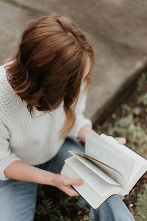 woman sitting outside reading book