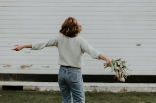 woman holding pink petaled flower