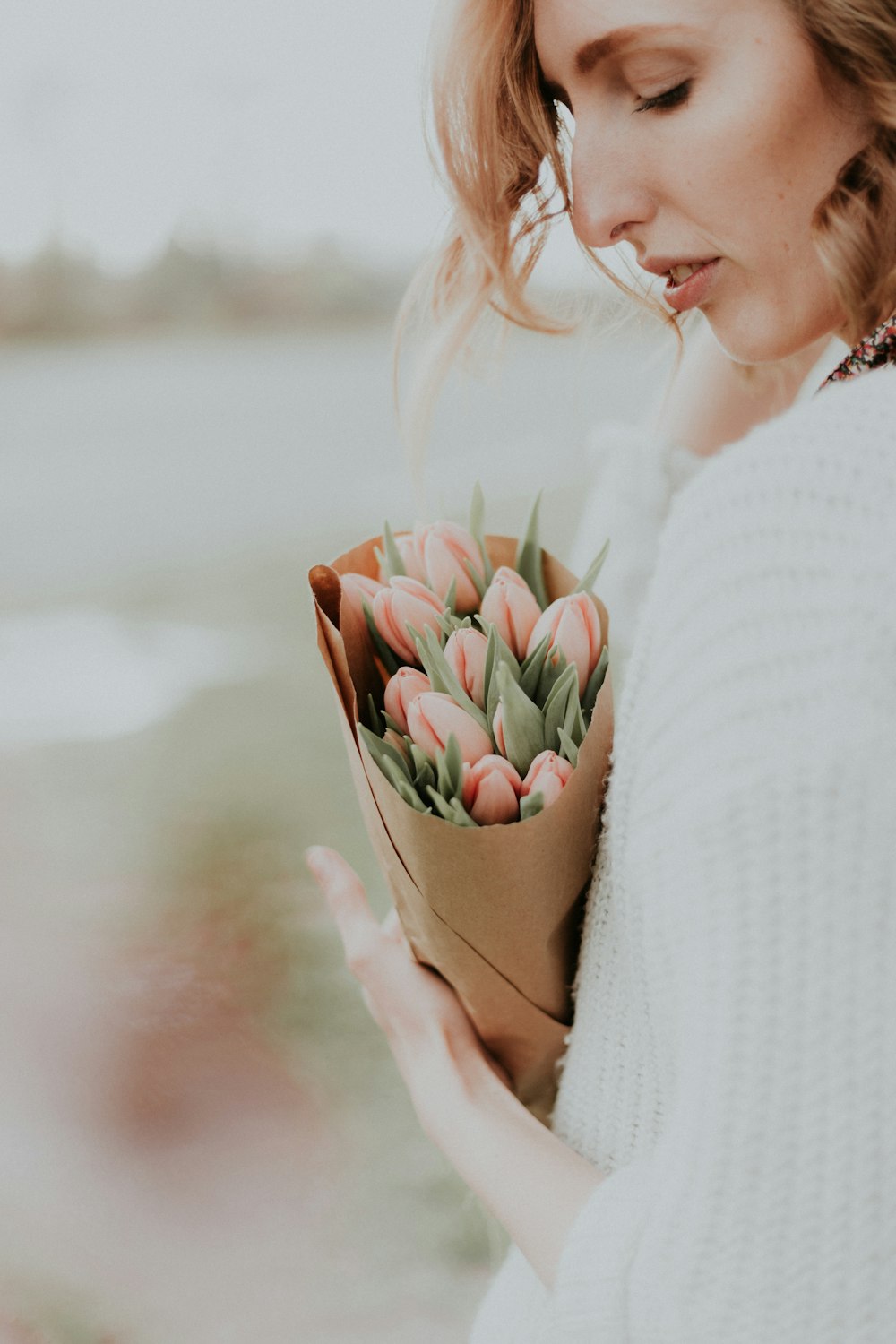 Frau hält Strauß rosa Tulpenblüten