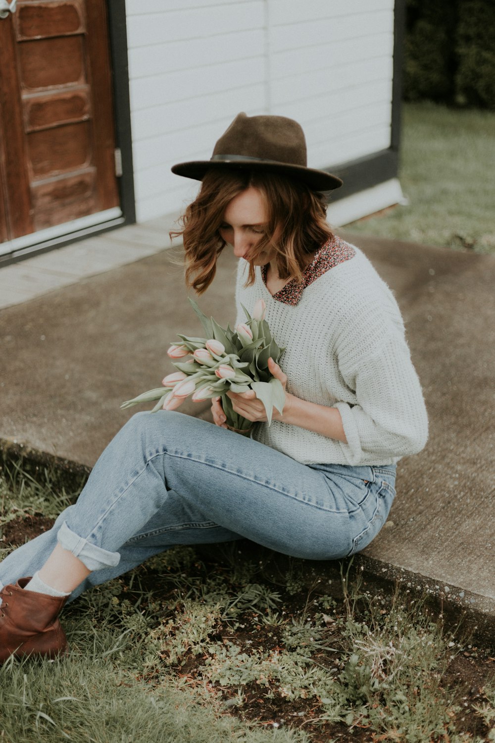 woman sitting on ground holding bouquet of tulips