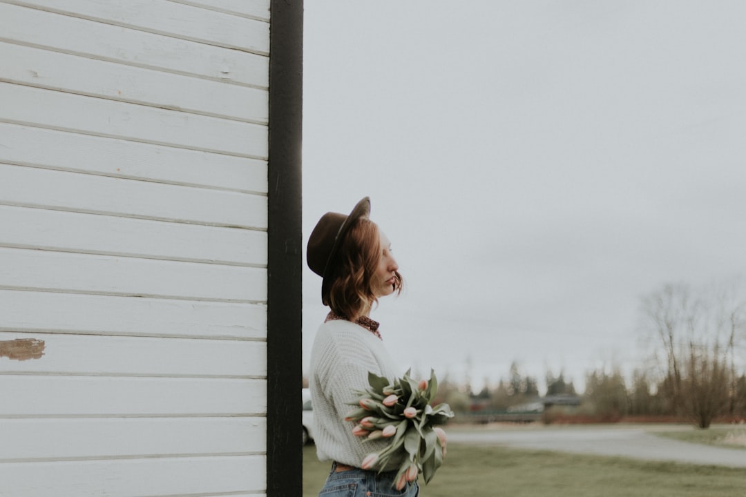 woman standing near white wooden wall