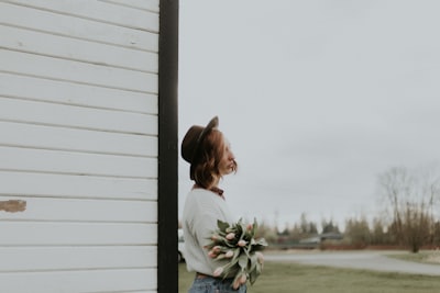 woman standing near white wooden wall mother's day teams background