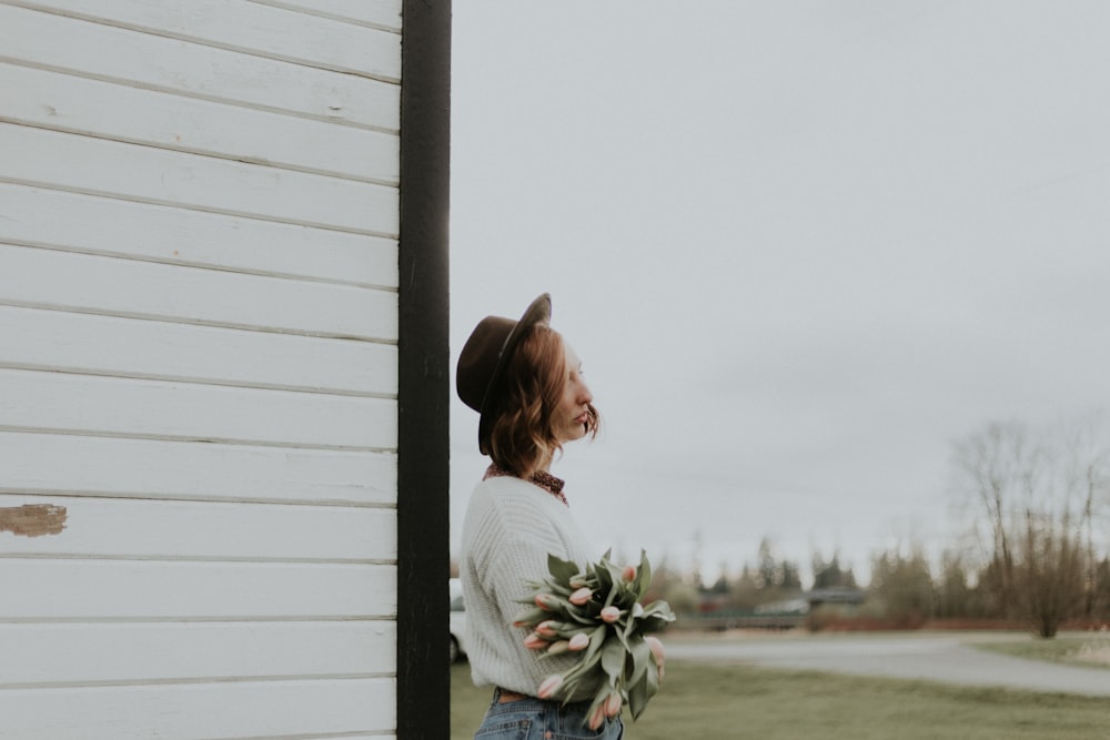 woman standing near white wooden wall