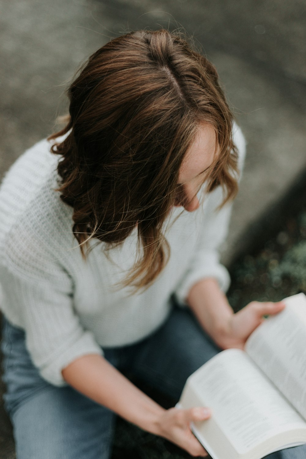 Mujer sentada en el suelo mientras lee un libro