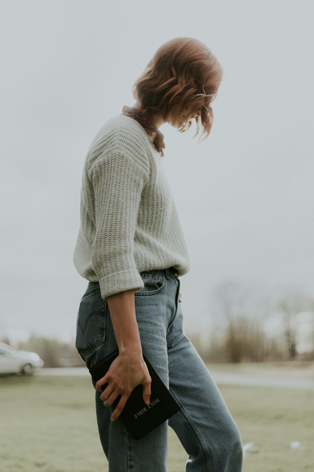 Une femme debout dans un champ avec sa main sur sa hanche