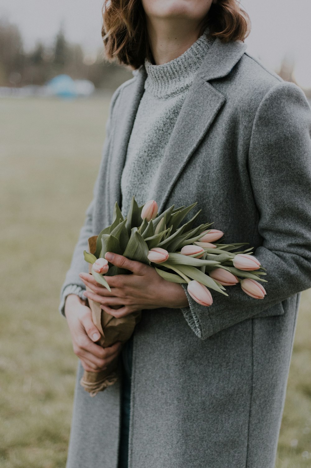 woman holding pink tulips