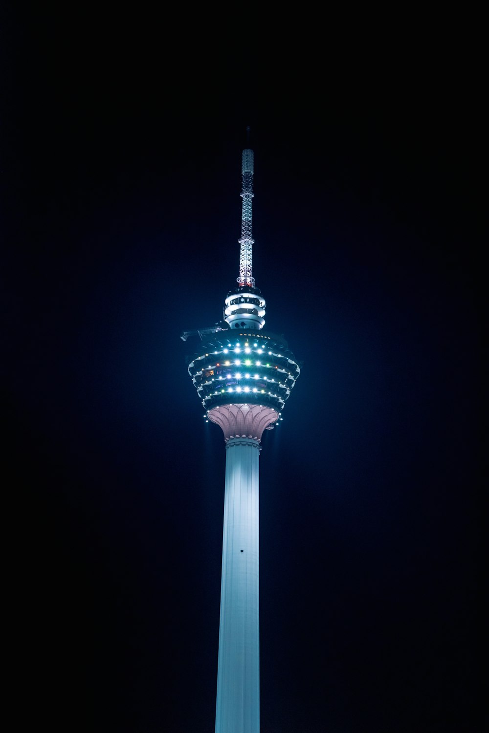 teal and red tower during night time