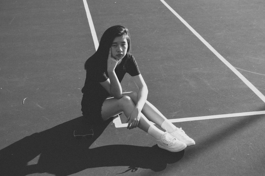 girl sitting on concrete pavement with white line