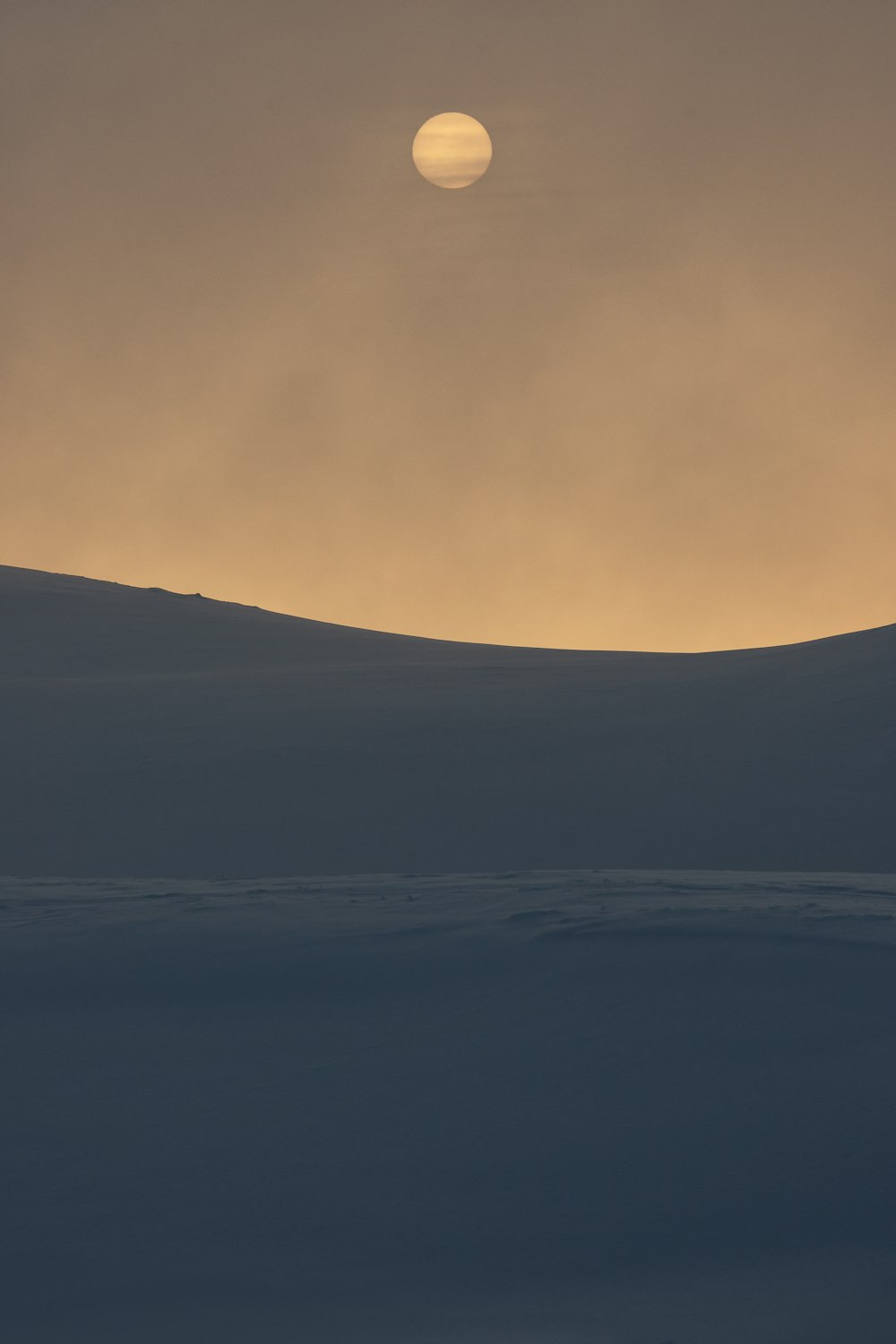 Il sole sta tramontando su una collina innevata