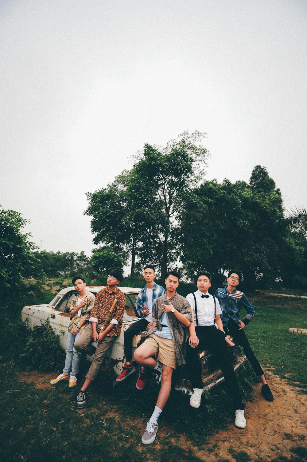 six men sitting on white car