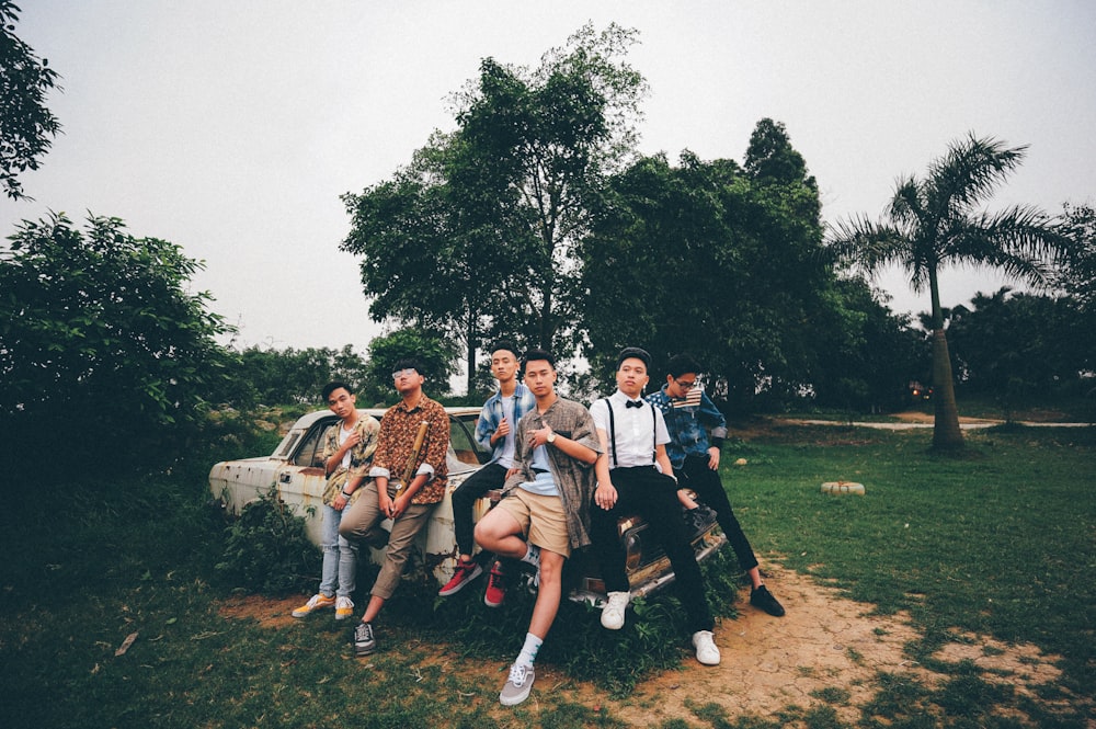 group of boys sitting on abandonned car